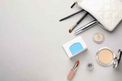 Flat lay composition with facial oil blotting tissues and makeup products on light grey background, space for text. Mattifying wipes