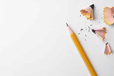 Photo of Graphite pencil and shavings on white background, flat lay. Space for text