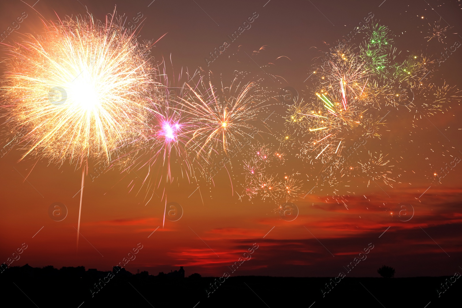 Image of Beautiful bright fireworks lighting up twilight sky outdoors