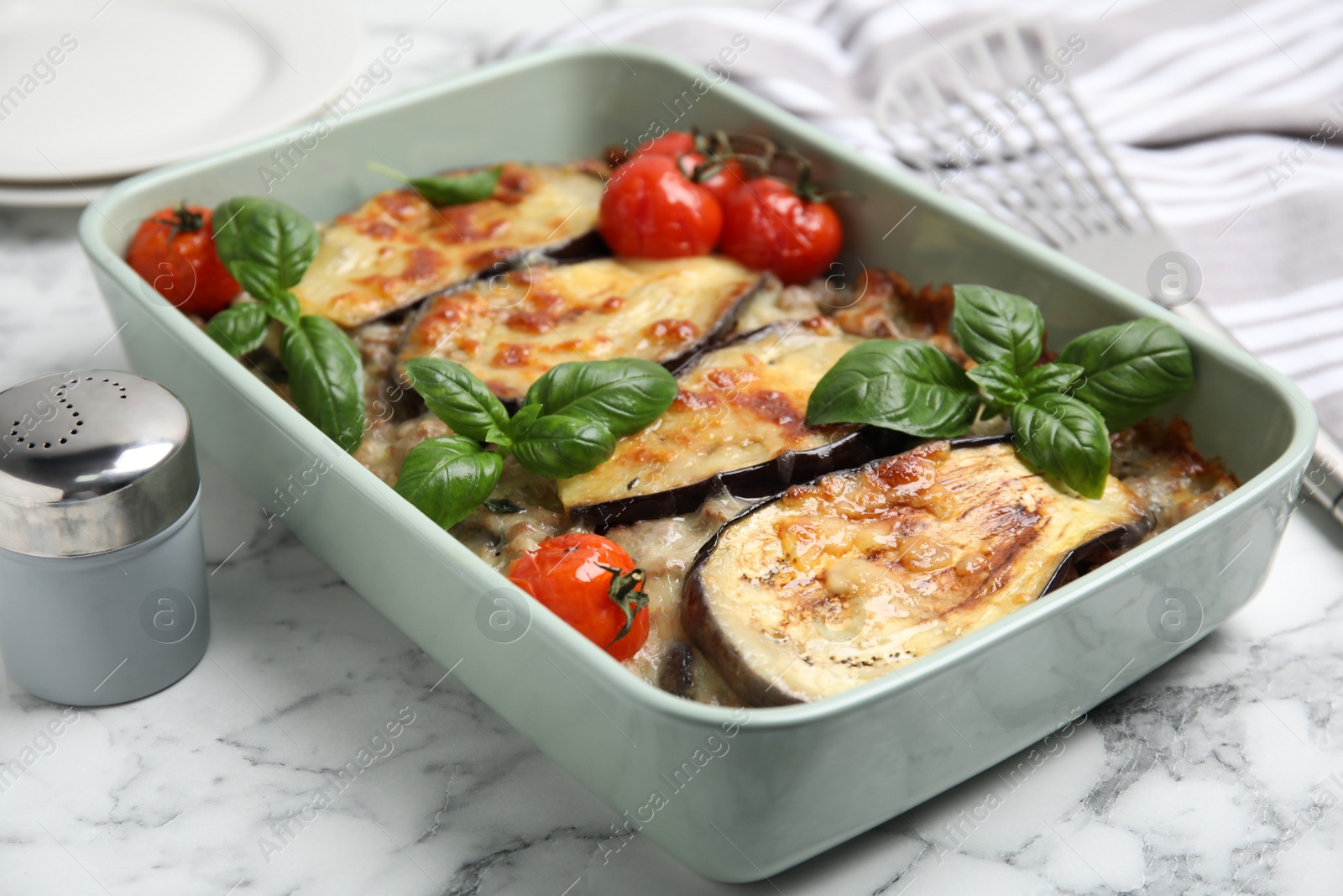 Photo of Delicious eggplant lasagna in baking dish on white marble table