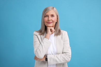 Photo of Portrait of beautiful middle aged woman on light blue background