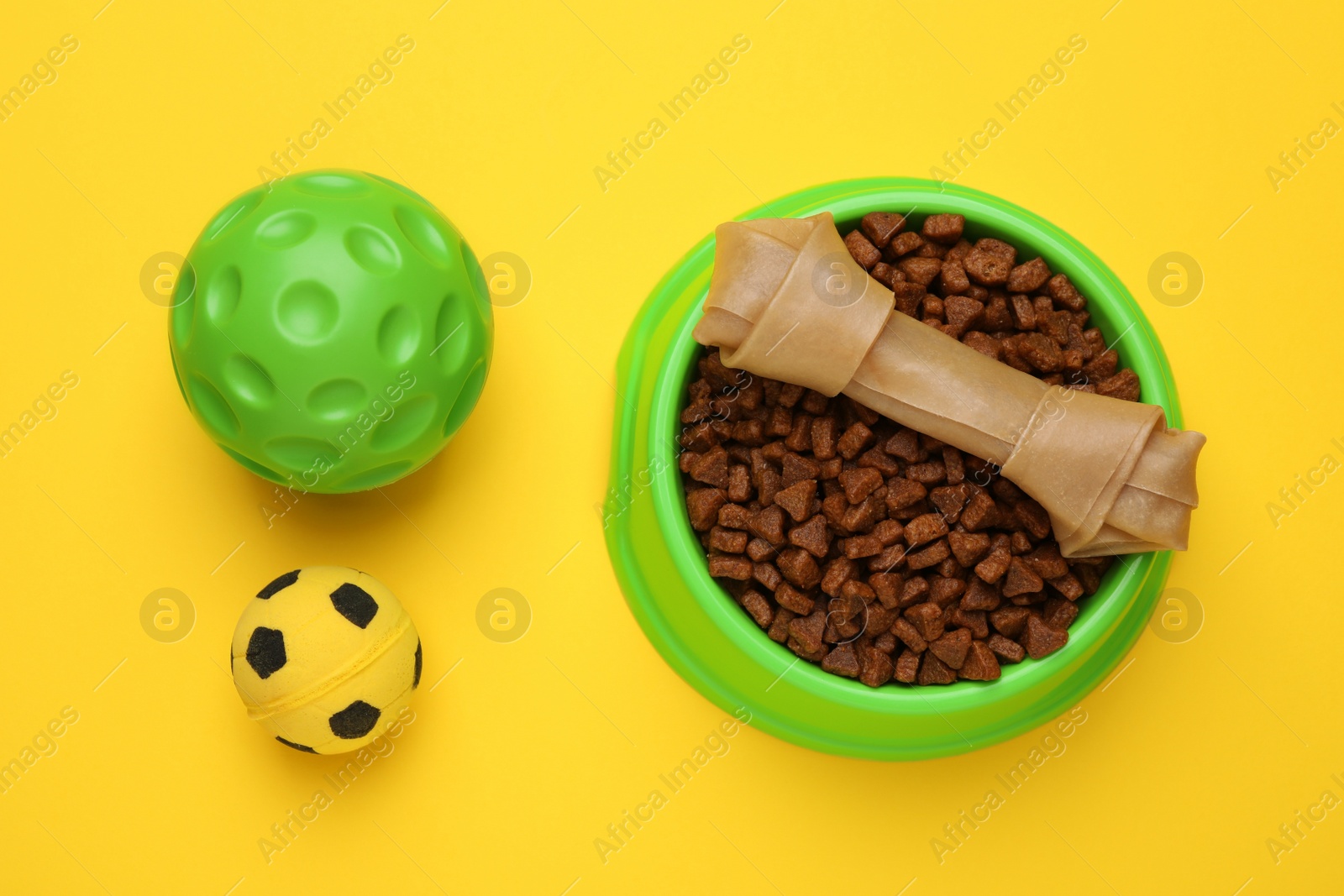 Photo of Pet toys and food on yellow background, flat lay