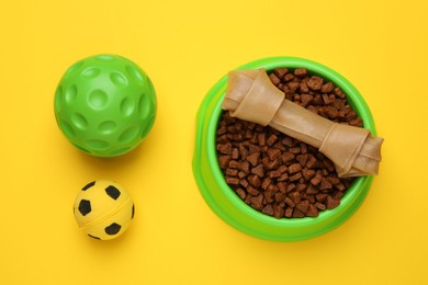 Pet toys and food on yellow background, flat lay