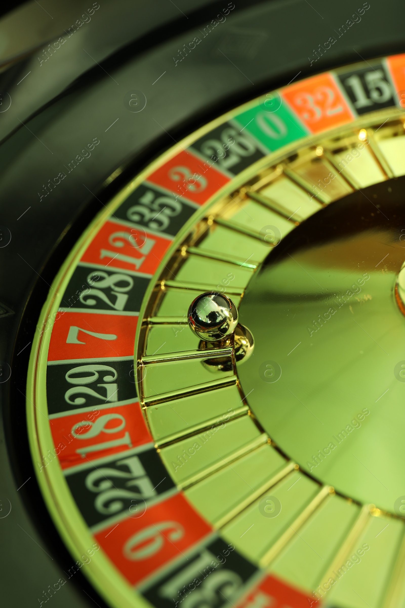 Photo of Roulette wheel with ball, closeup. Casino game