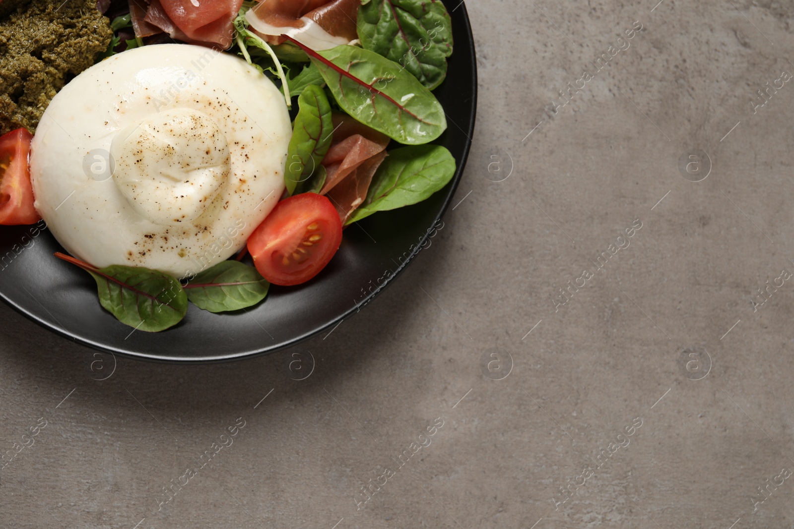 Photo of Delicious burrata salad on light grey table, top view. Space for text