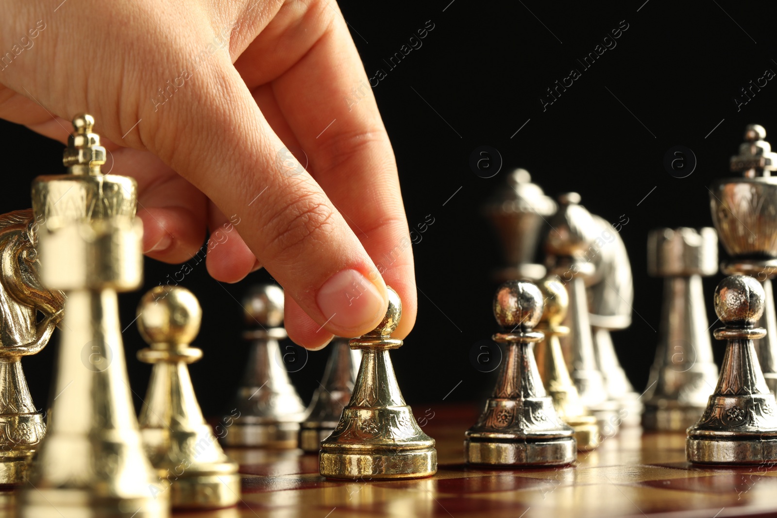 Photo of Woman moving chess piece on board, closeup