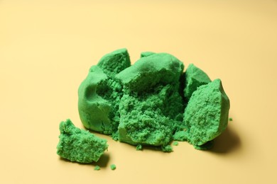 Photo of Green kinetic sand on beige background, closeup