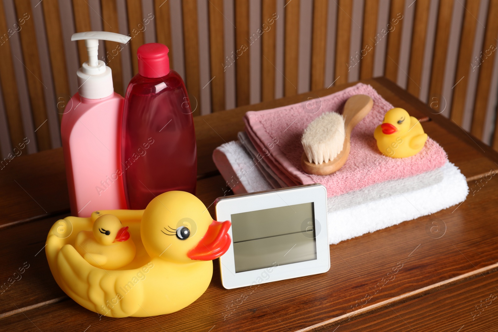 Photo of Bathroom towels, toys and baby accessories on wooden table