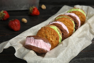 Photo of Different sweet delicious ice cream cookie sandwiches served on table