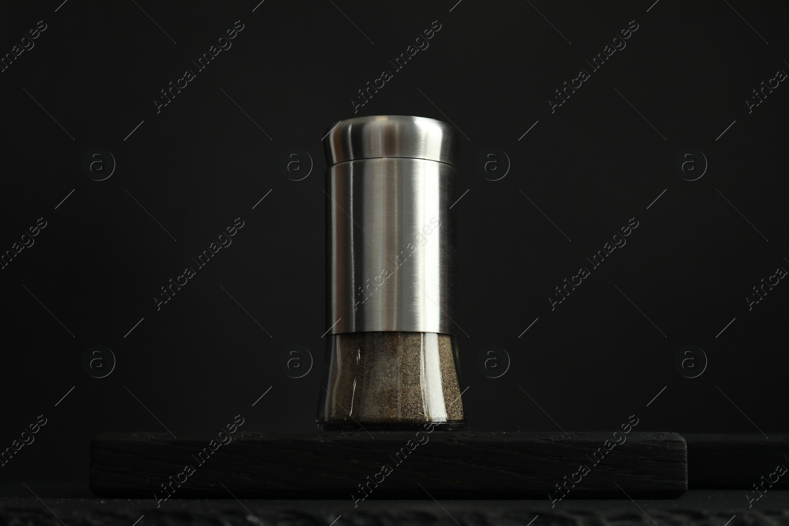 Photo of Pepper shaker on table against black background