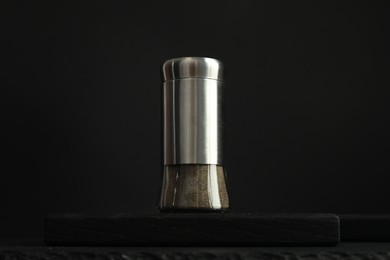 Pepper shaker on table against black background