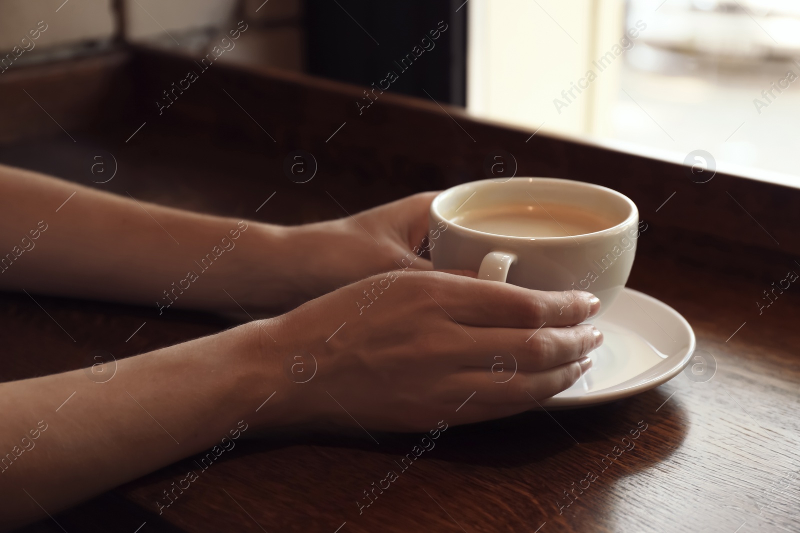 Photo of Woman with cup of fresh aromatic coffee at table