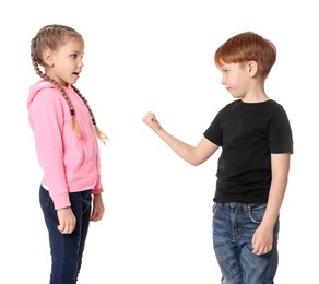 Photo of Boy with clenched fist looking at girl on white background. Children's bullying