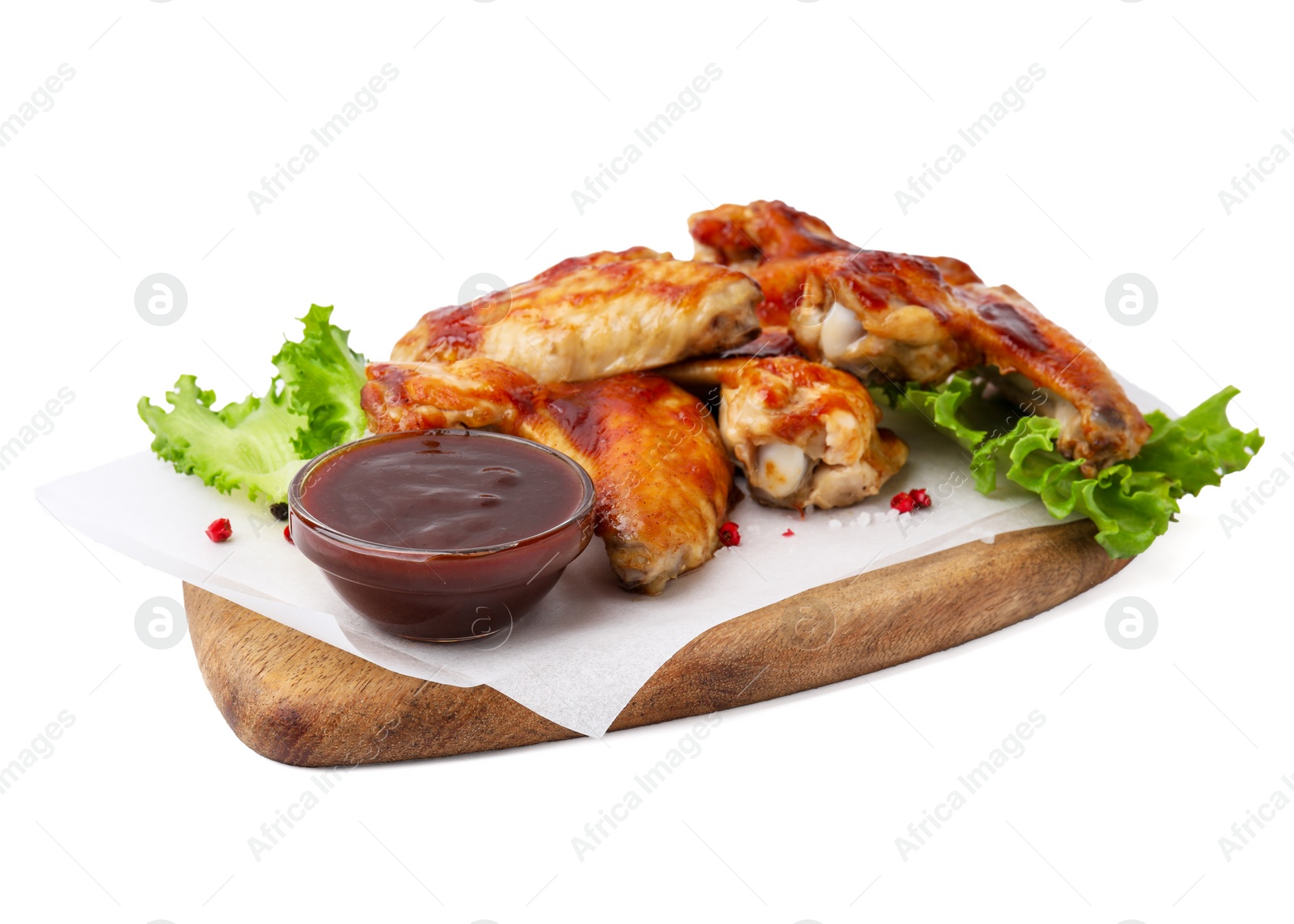 Photo of Board with marinade, chicken wings, spices and lettuce isolated on white