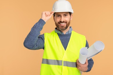 Architect in hard hat with drafts on beige background