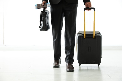 Photo of Businessman with black travel suitcase in airport. Space for text