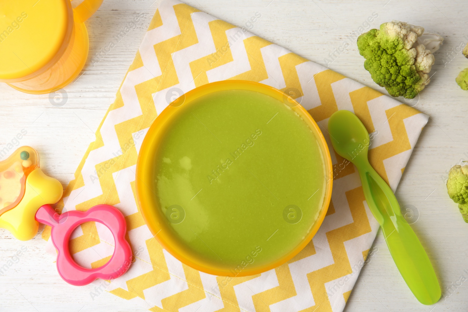 Photo of Flat lay composition with bowl of healthy baby food on wooden background