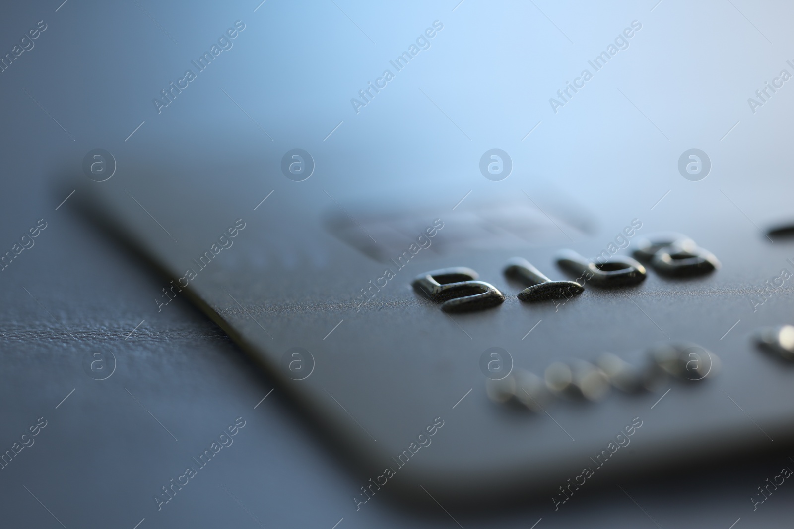 Photo of One credit card on gray background, macro view