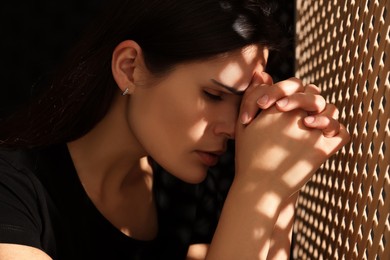 Upset woman listening to priest during confession in booth