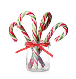 Photo of Sweet Christmas candy canes in jar on white background