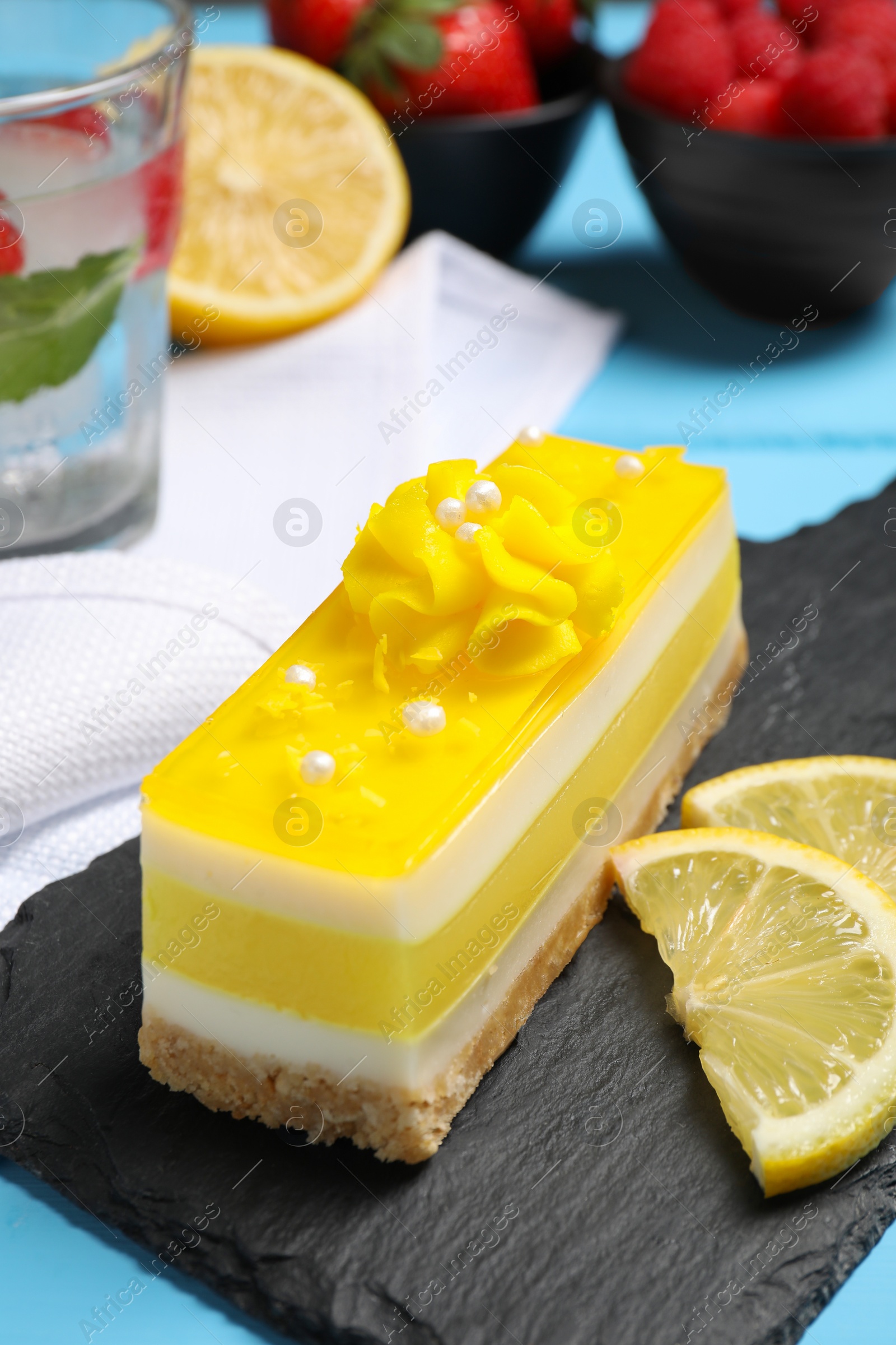 Photo of Delicious cheesecake with lemon on light blue table