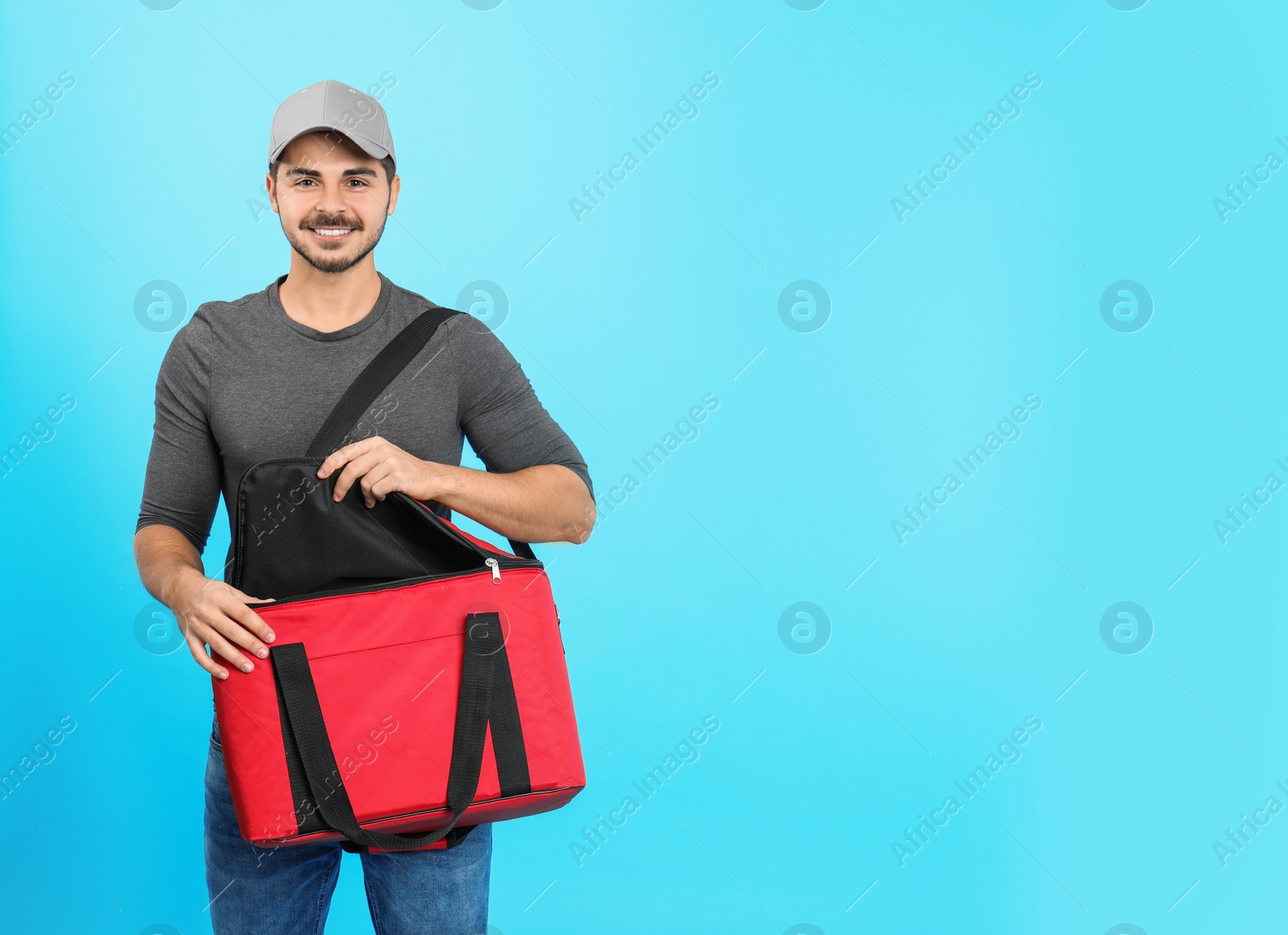 Photo of Young courier with thermo bag on color background, space for text. Food delivery service