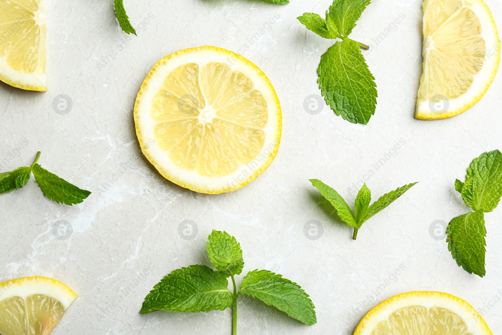 Photo of Fresh mint with sliced lemon on grey marble background, flat lay