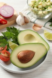 Fresh ingredients for guacamole on white wooden table