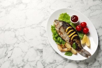 Photo of Tasty homemade roasted crucian carp with garnish on white marble table, top view and space for text. River fish