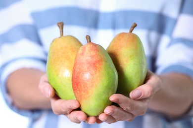 Photo of Woman holding fresh ripe juicy pears, closeup
