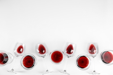 Composition with glasses of wine on white background, top view