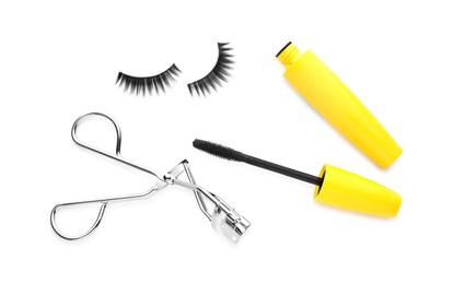 Photo of False eyelashes, curler and mascara on white background, top view