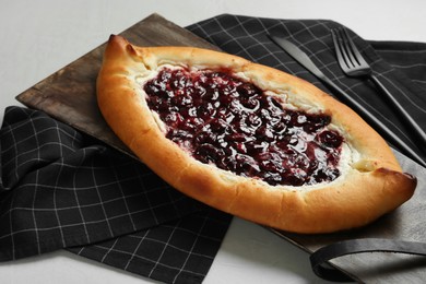 Photo of Delicious sweet cottage cheese pastry with cherry jam served on light table