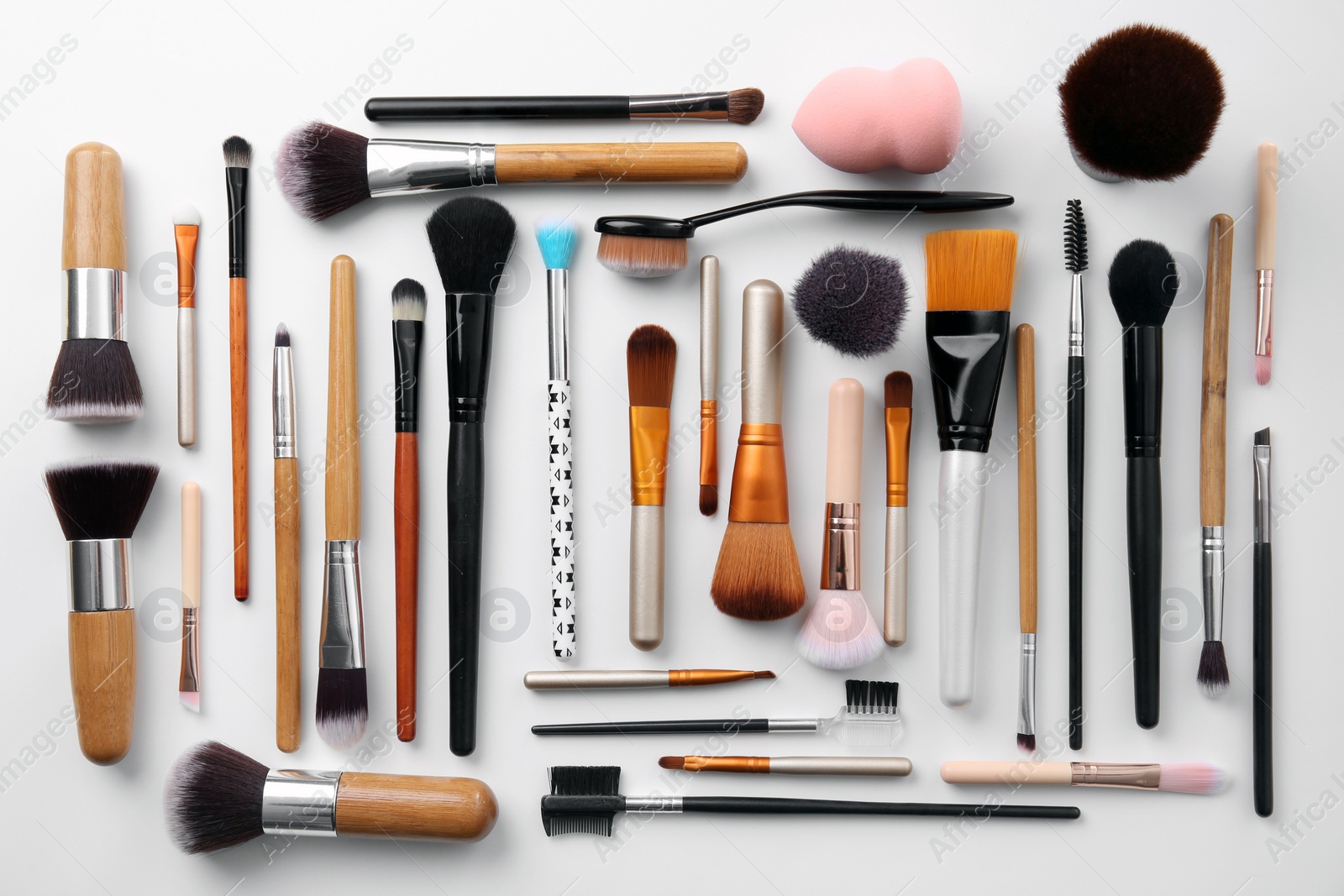 Photo of Flat lay composition with makeup brushes of professional artist on white background