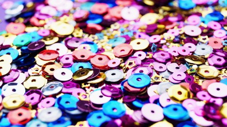 Photo of Many different colorful sequins as background, closeup