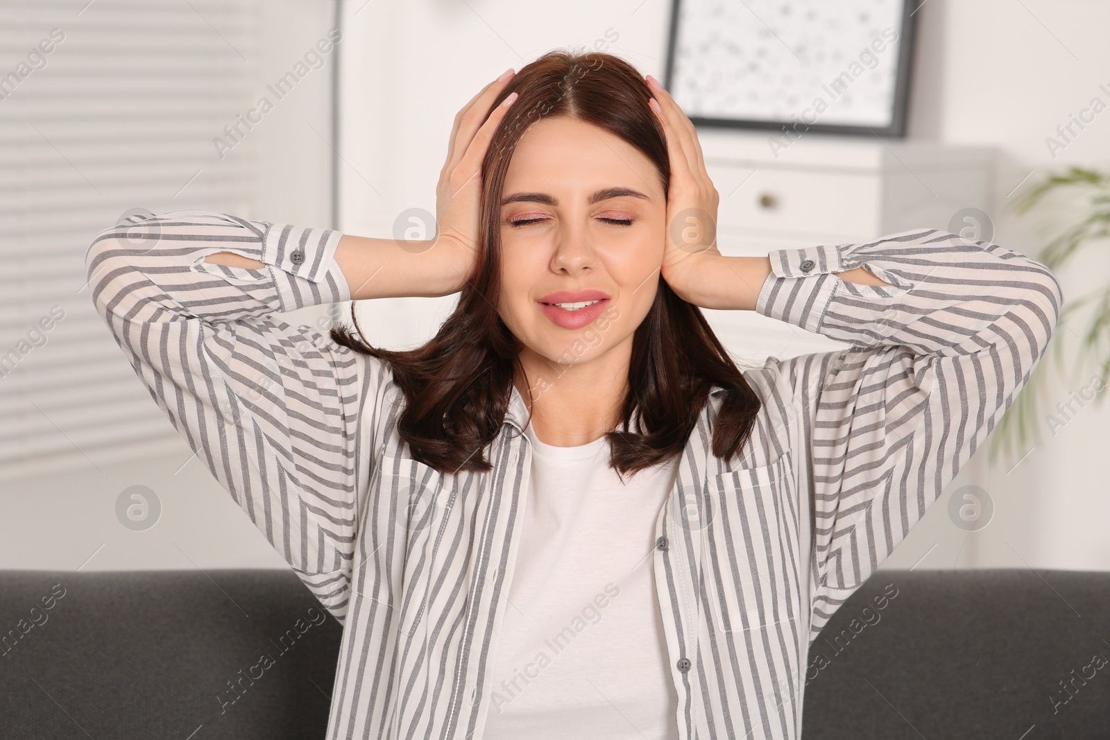 Photo of Young woman suffering from headache indoors. Hormonal disorders