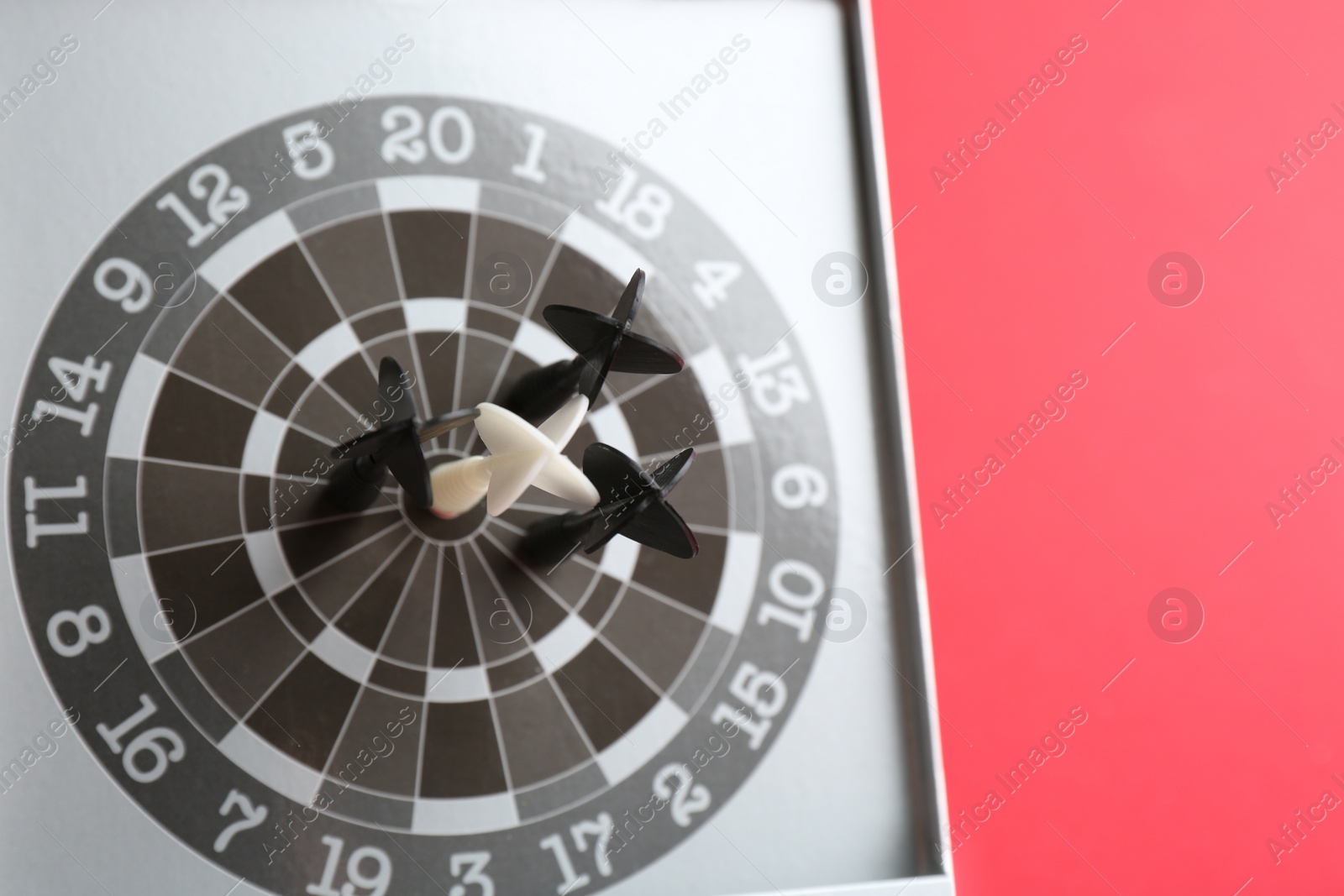 Photo of Different darts in board on red background. Career promotion concept