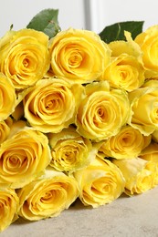 Beautiful bouquet of yellow roses on light grey table, closeup