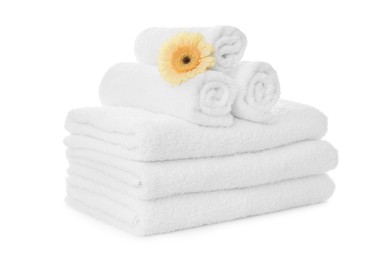 Fresh clean towels with gerbera on white background