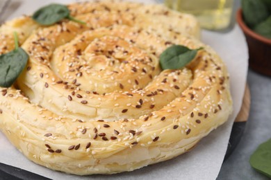 Photo of Delicious puff pastry with spinach on grey table, closeup