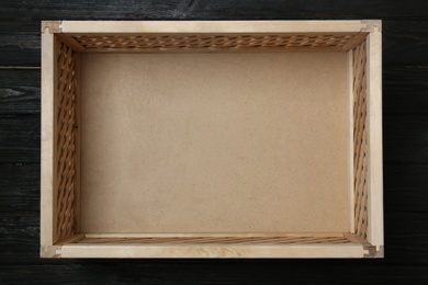 Photo of Empty wooden crate on dark background, top view