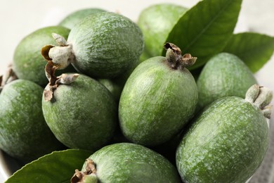 Delicious fresh feijoas and leaves on light background, closeup