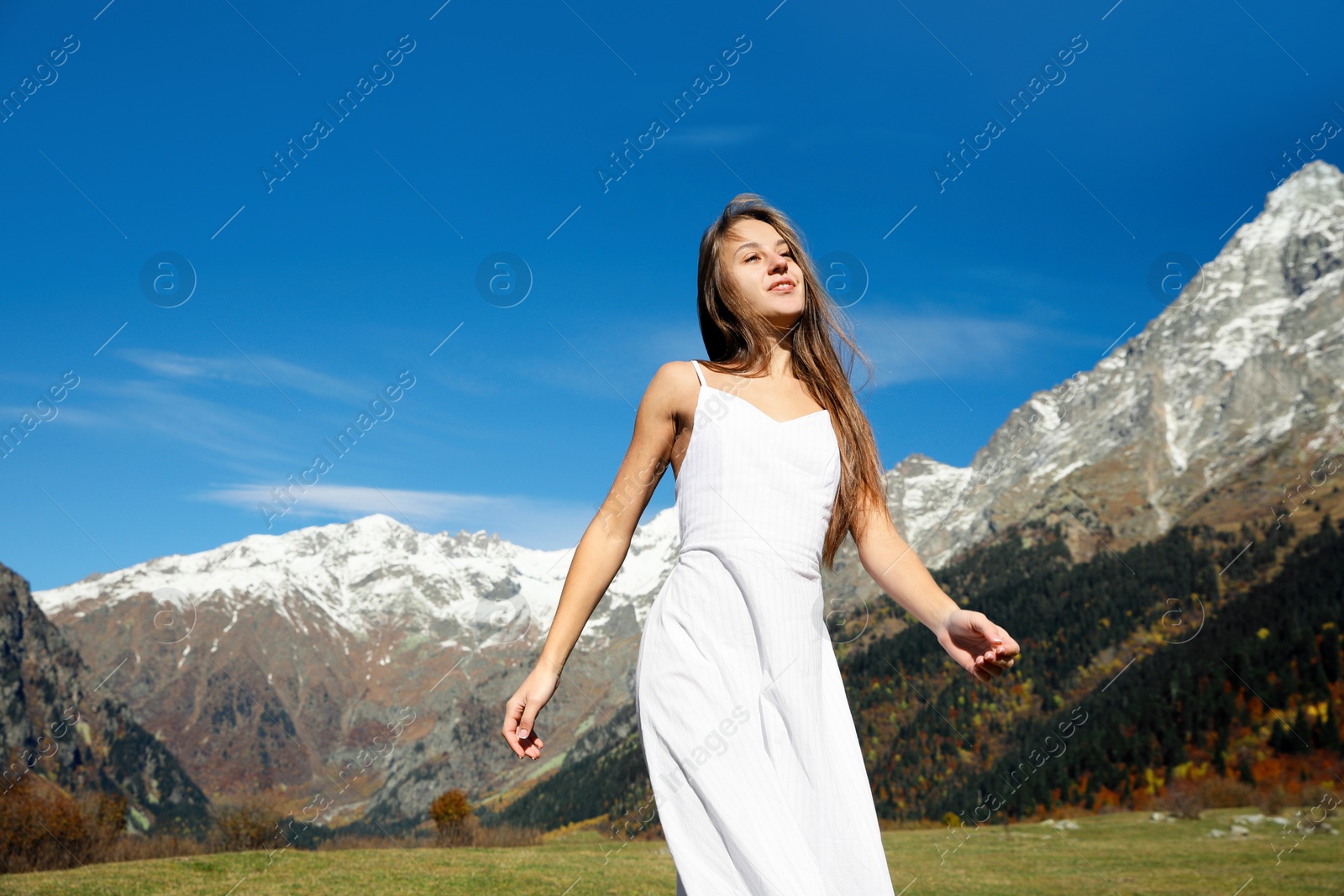 Photo of Young woman walking in beautiful mountains on sunny day