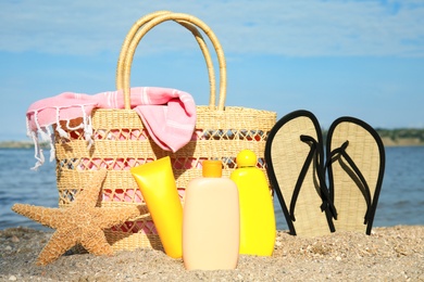 Composition with bottles of sun protection body cream on beach, space for design