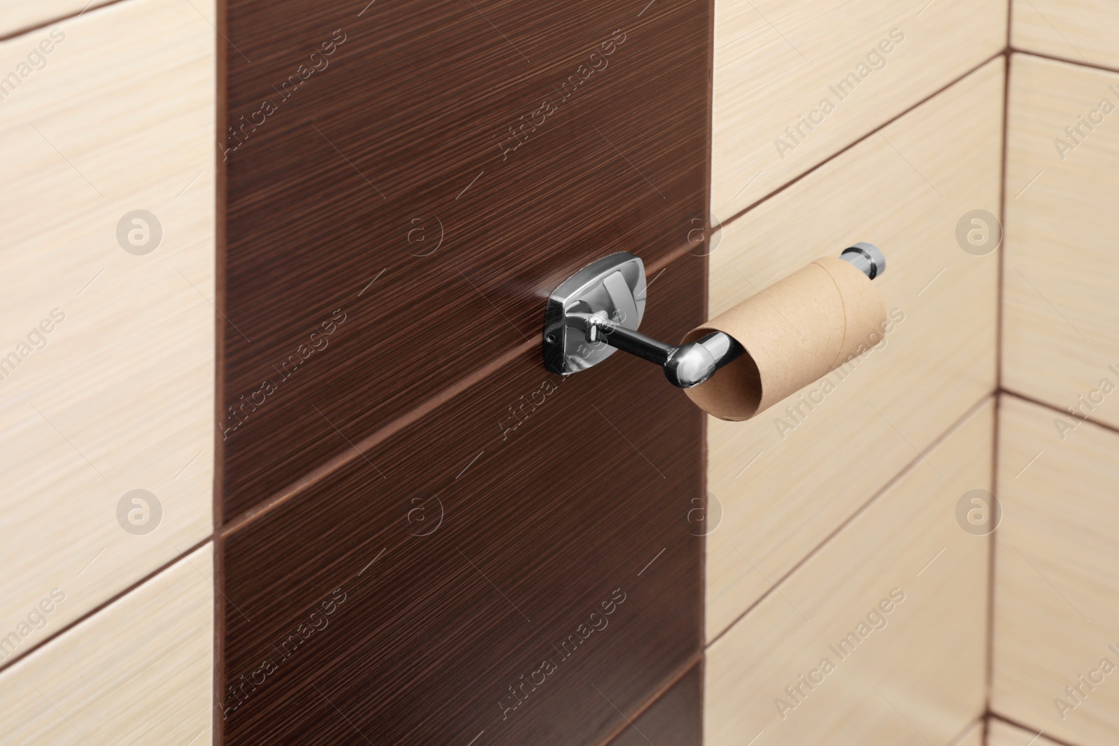 Photo of Holder with empty toilet paper roll in bathroom