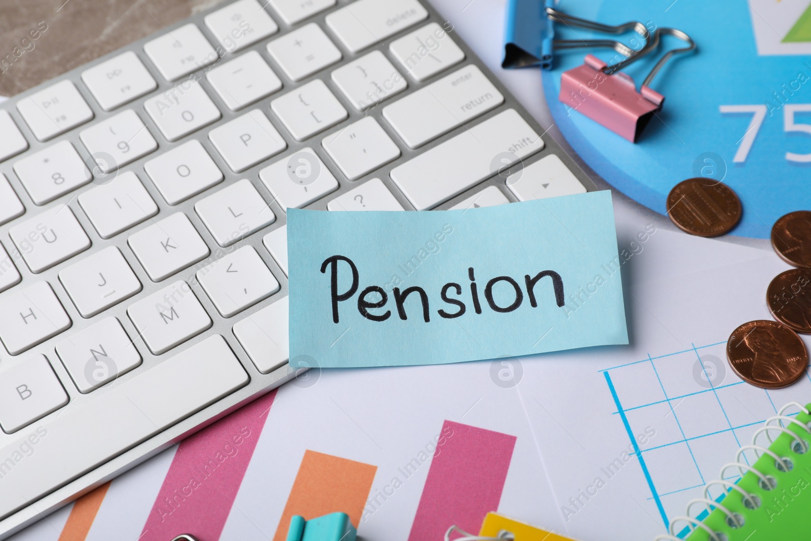 Photo of Paper with word PENSION, stationery, keyboard, coins and charts on table