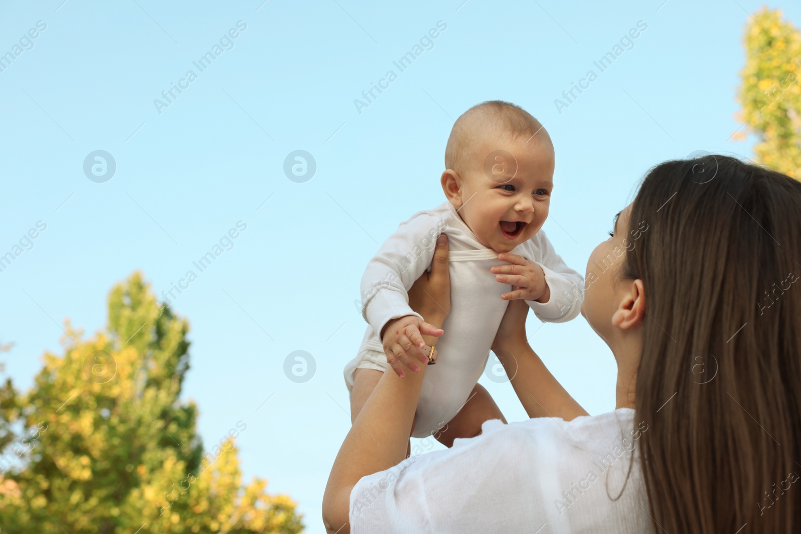 Photo of Mother with her cute baby outdoors on sunny day