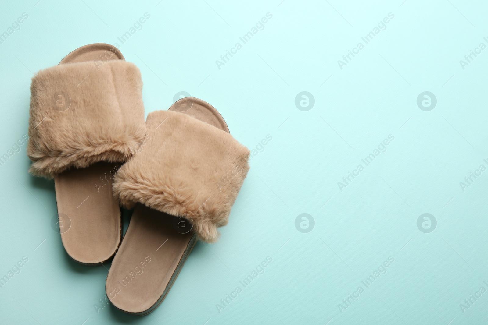 Photo of Pair of soft slippers on light blue background, flat lay. Space for text