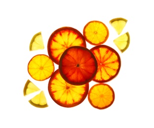 Photo of Illuminated slices of citrus fruits on white background, top view