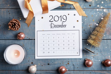 Photo of Flat lay composition with paper calendar on blue wooden table